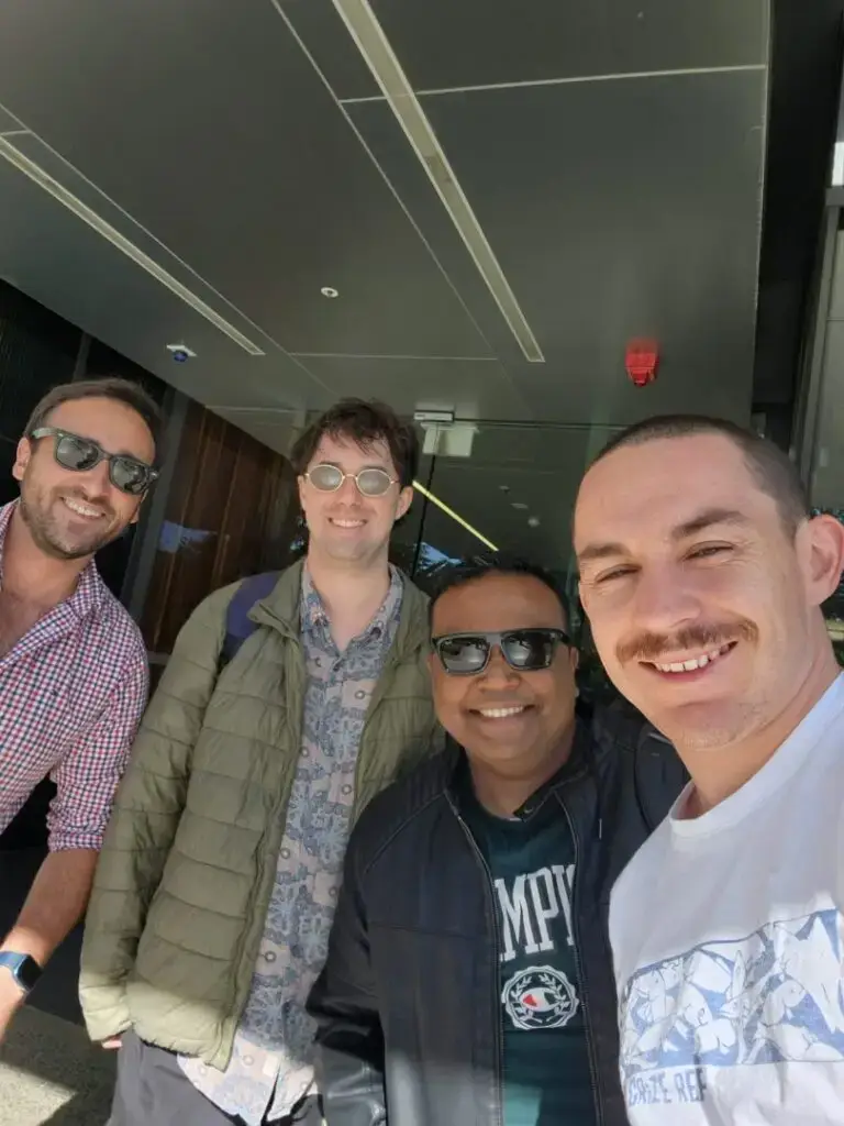 Four friends posing for a selfie outdoors.