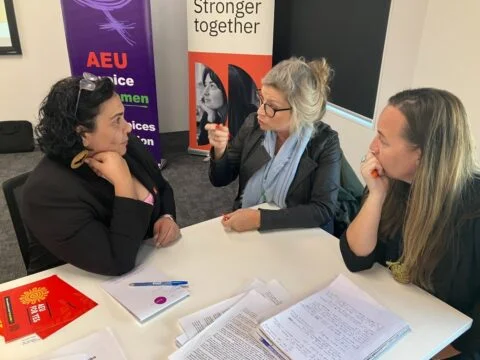 Three professionals discussing at union meeting.