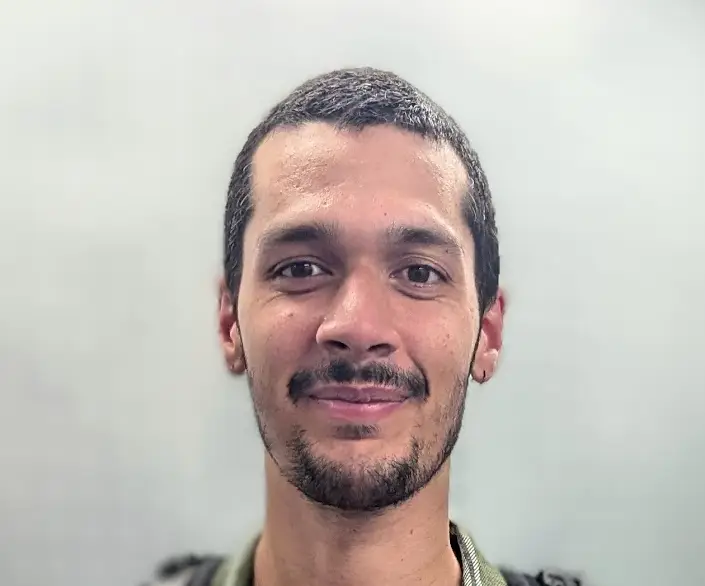 Trilokesh Chanmugam Smiling individual with short hair and beard.