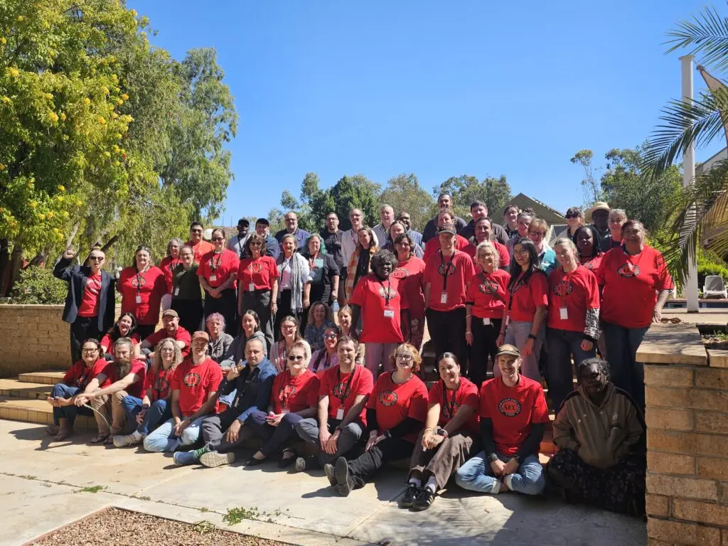 Large group in red shirts posing outdoors