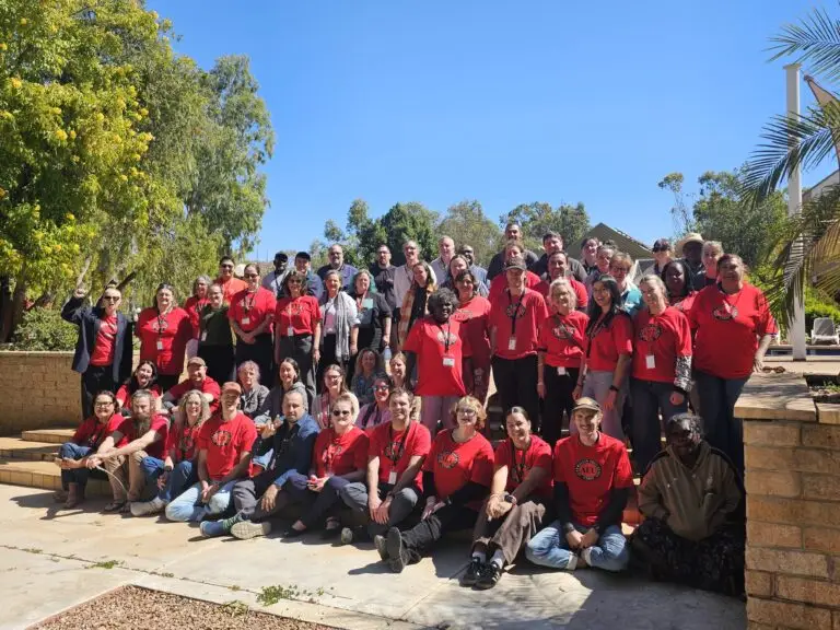 Large group in red shirts posing outdoors