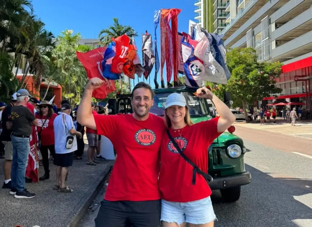 AEU supporters pose beside flag-covered truck at rally