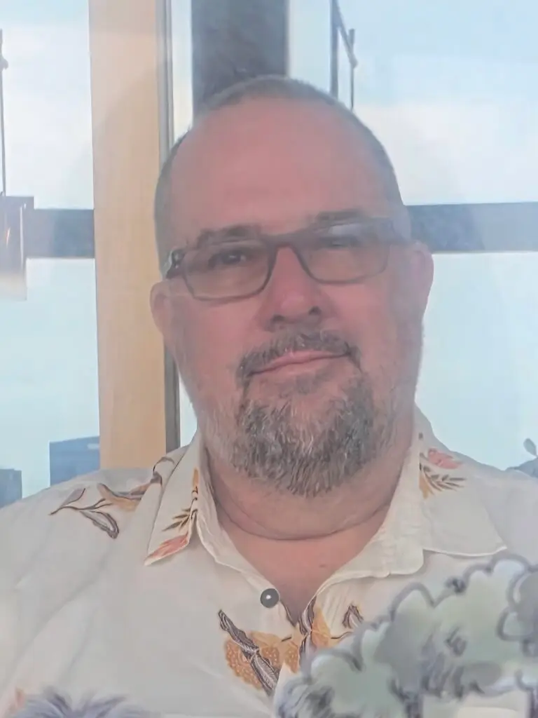 Smiling man in glasses wearing a floral shirt