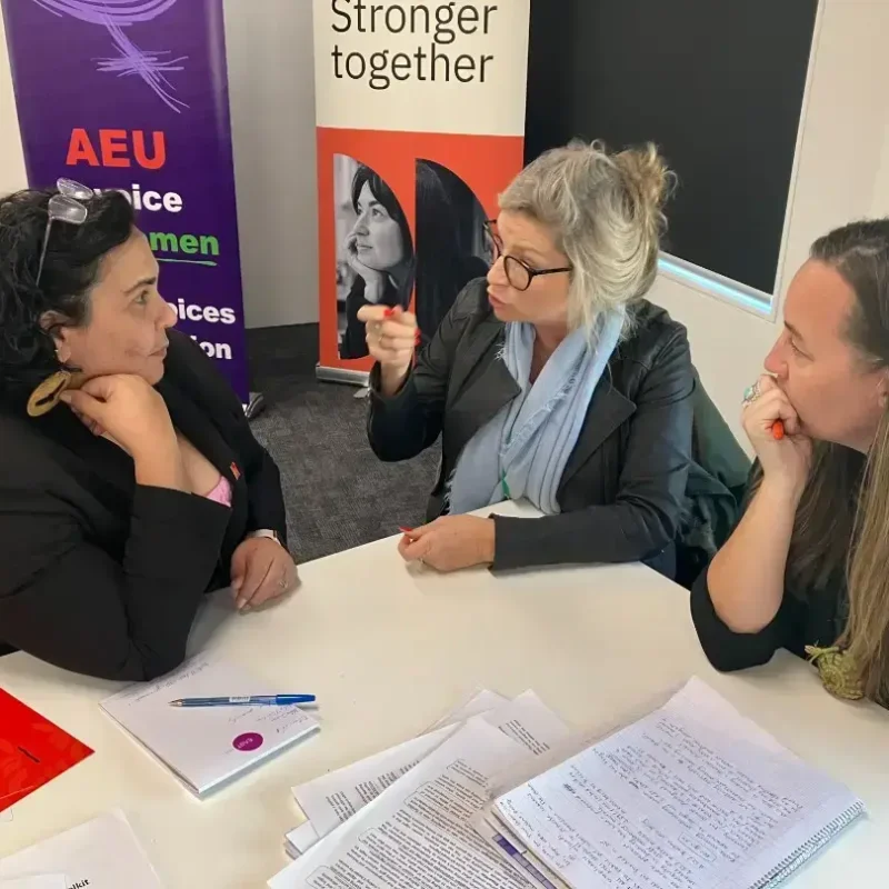 Three professionals discussing at union meeting.